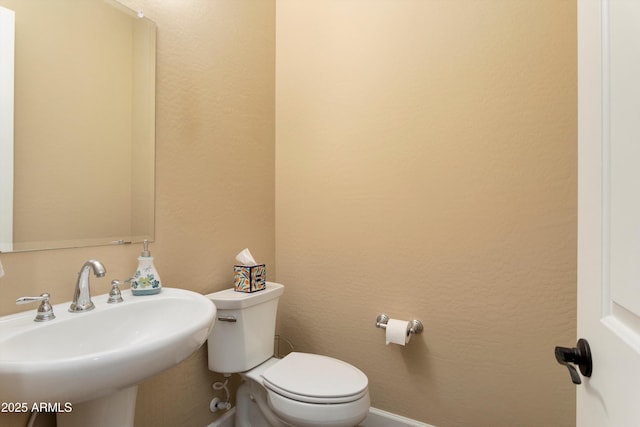 half bathroom with toilet and a sink