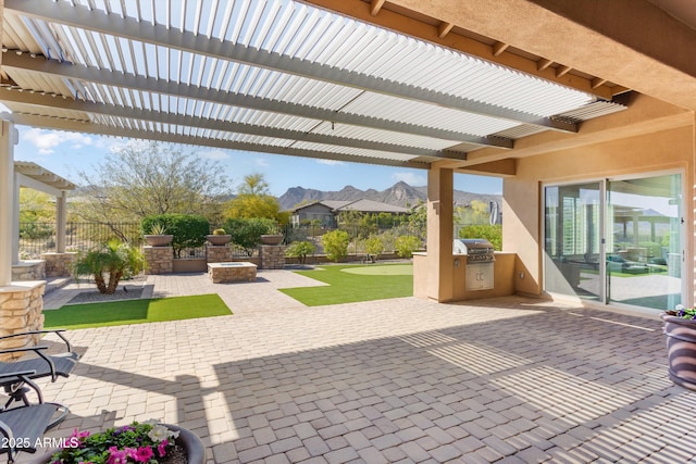 view of patio featuring a mountain view, a grill, a pergola, exterior kitchen, and fence