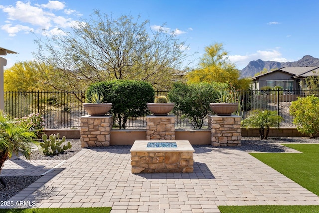 view of patio / terrace with a mountain view, fence, and a fire pit