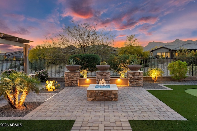 patio terrace at dusk with a fire pit and fence