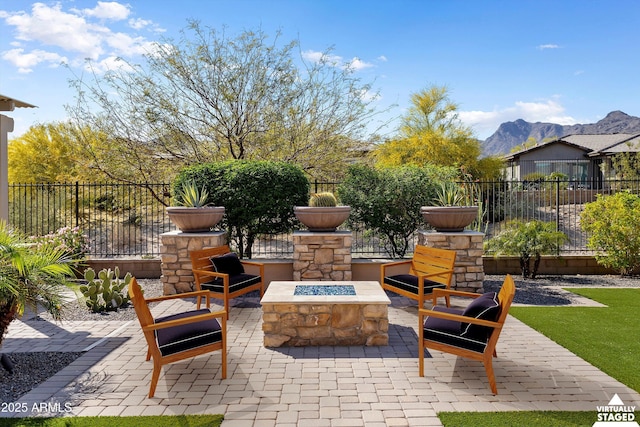 view of patio / terrace with a fire pit, a mountain view, and fence