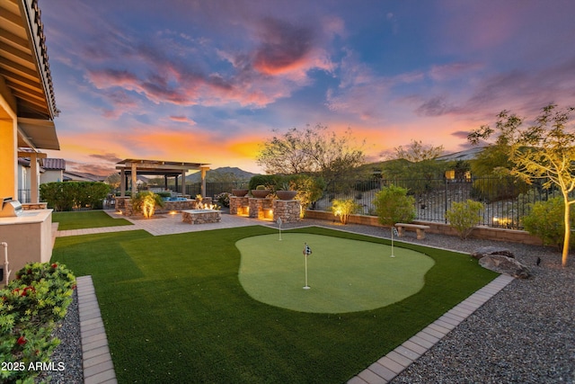 yard at dusk featuring a fire pit, a pergola, area for grilling, a fenced backyard, and a patio