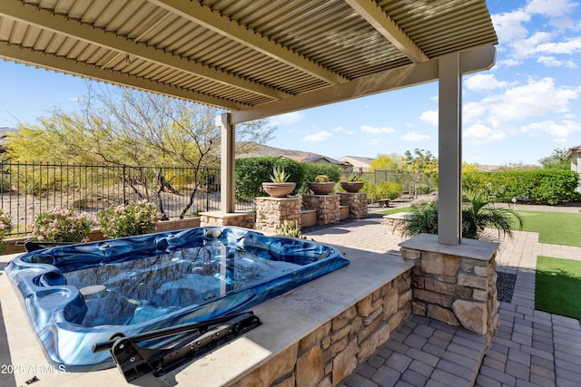 view of patio / terrace featuring fence and an outdoor hot tub