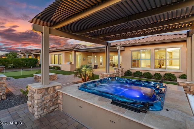 exterior space featuring a patio area, an outdoor hot tub, and a pergola