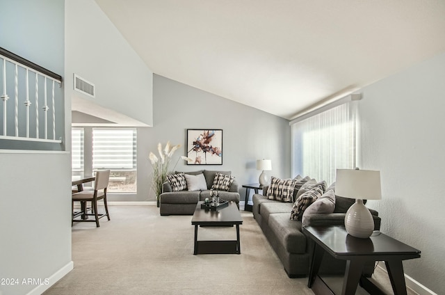 living room with vaulted ceiling and light carpet