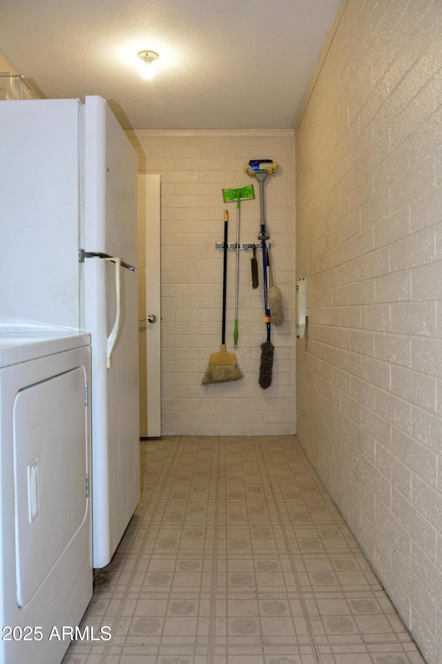 3519 W Libby St, Glendale, AZ 85308 - laundry room featuring washer / clothes dryer, brick wall, and light floors