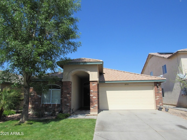 view of front facade with a garage, a front yard, concrete driveway, and brick siding