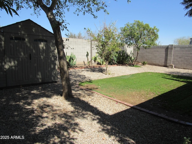 view of yard with an outbuilding, a shed, and a fenced backyard