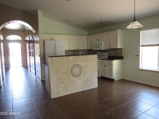 kitchen featuring a healthy amount of sunlight, white appliances, arched walkways, and vaulted ceiling