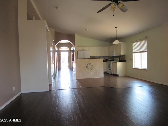 kitchen with arched walkways, white appliances, white cabinets, a center island, and dark wood finished floors