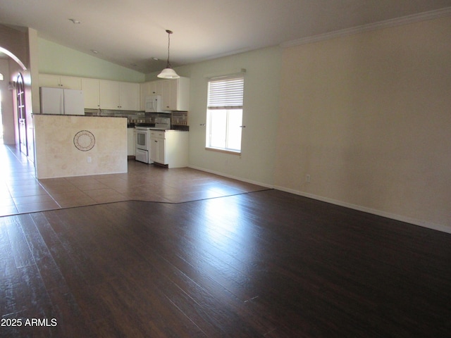 unfurnished living room with arched walkways, dark wood finished floors, lofted ceiling, ornamental molding, and baseboards