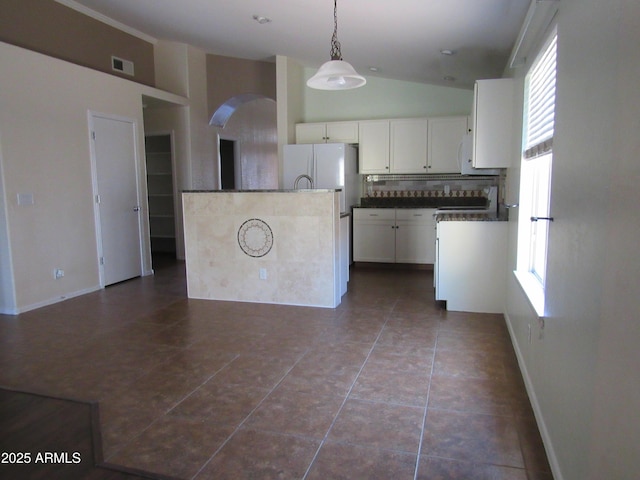 kitchen with visible vents, white cabinets, hanging light fixtures, freestanding refrigerator, and dark countertops