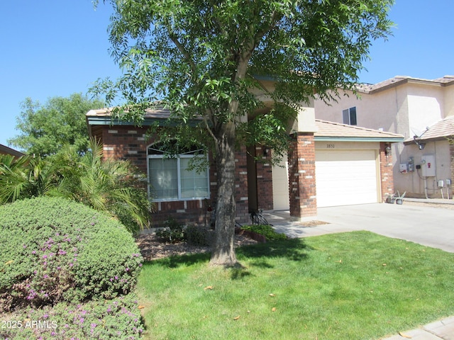 view of front of house with an attached garage, brick siding, driveway, and a front lawn