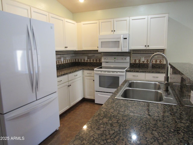 kitchen with white appliances, white cabinets, a sink, dark tile patterned floors, and backsplash