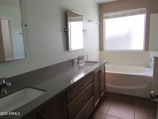 bathroom featuring tile patterned floors, double vanity, a sink, and a bath