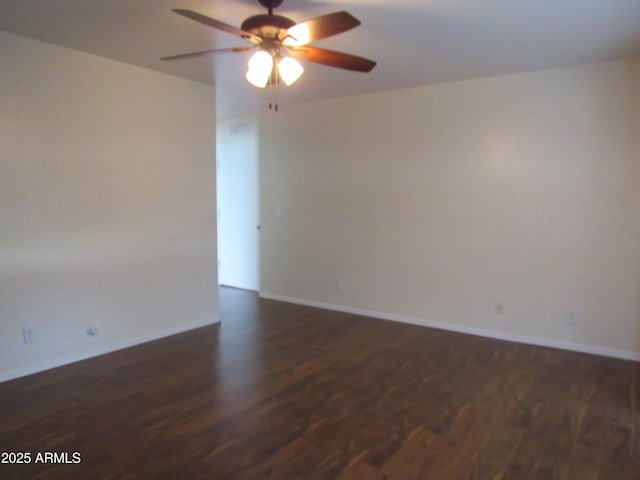 empty room featuring dark wood-style floors, ceiling fan, and baseboards