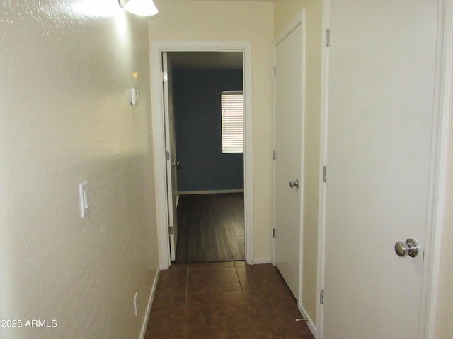 hallway featuring baseboards and tile patterned floors