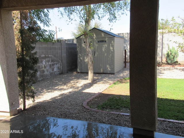 view of yard featuring a storage shed, an outbuilding, and a fenced backyard