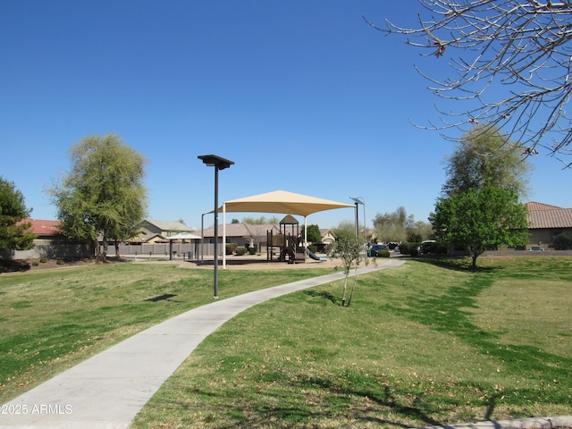 view of home's community featuring playground community and a yard