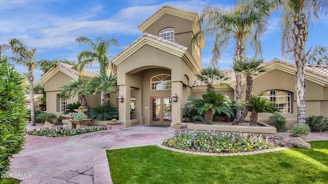 5335 E Shea Blvd Unit 1094, Scottsdale, AZ 85254 - mediterranean / spanish house featuring french doors, stucco siding, a tile roof, and a front lawn