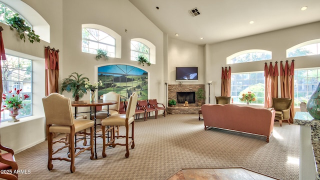 5335 E Shea Blvd Unit 1094, Scottsdale, AZ 85254 - dining room featuring carpet floors, a towering ceiling, healthy amount of natural light, a stone fireplace, and recessed lighting