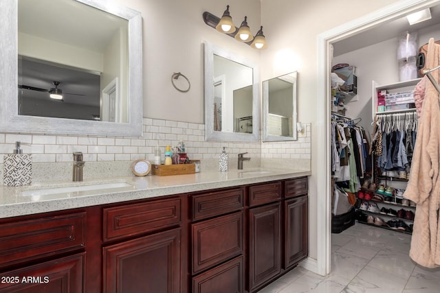 205 N 107th Dr, Avondale, AZ 85323 - full bathroom featuring marble finish flooring, double vanity, tasteful backsplash, a ceiling fan, and a walk in closet