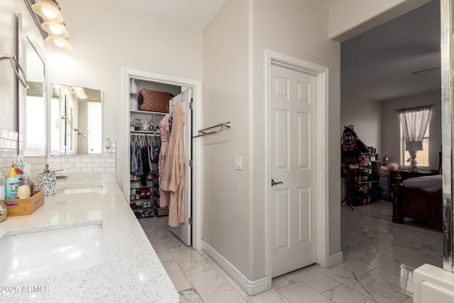 205 N 107th Dr, Avondale, AZ 85323 - bathroom with healthy amount of natural light, double vanity, and marble look tiles