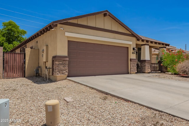 205 N 107th Dr, Avondale, AZ 85323 - view of front facade with stone siding, a gate, an attached garage, and board and batten siding