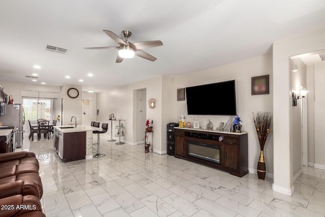 205 N 107th Dr, Avondale, AZ 85323 - living area featuring light marble finish floors, ceiling fan, recessed lighting, and a chandelier