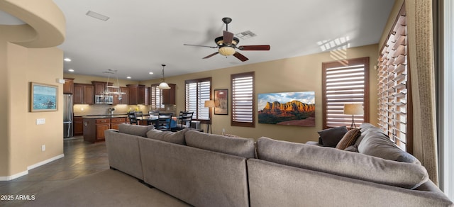living area featuring visible vents, baseboards, recessed lighting, dark tile patterned flooring, and a ceiling fan