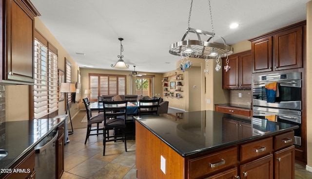 kitchen with a kitchen island, recessed lighting, appliances with stainless steel finishes, backsplash, and decorative light fixtures