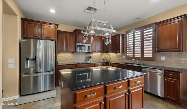 kitchen featuring appliances with stainless steel finishes, a sink, decorative backsplash, light tile patterned floors, and visible vents