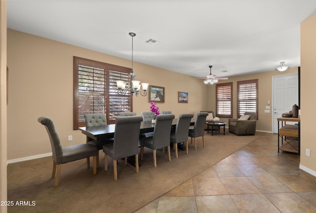 dining space featuring visible vents, baseboards, tile patterned floors, ceiling fan with notable chandelier, and carpet