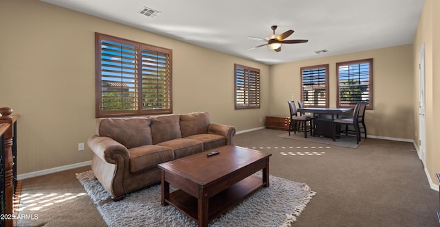 living room with baseboards, a ceiling fan, visible vents, and carpet flooring