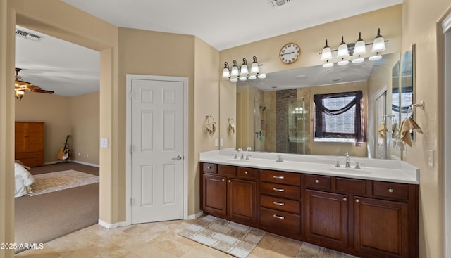 ensuite bathroom with visible vents, a ceiling fan, ensuite bathroom, a sink, and a stall shower