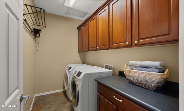 washroom featuring baseboards, cabinet space, and washer and dryer