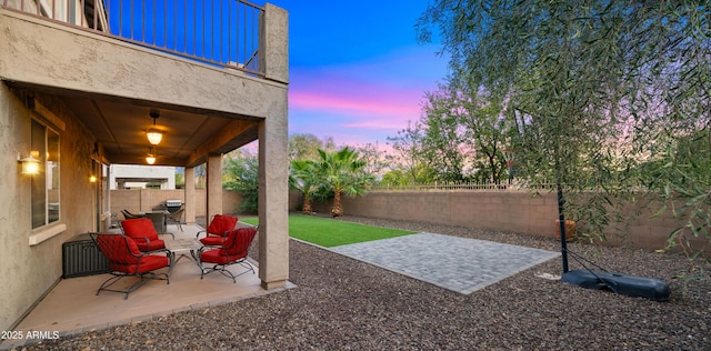 yard at dusk featuring a fenced backyard and a patio area