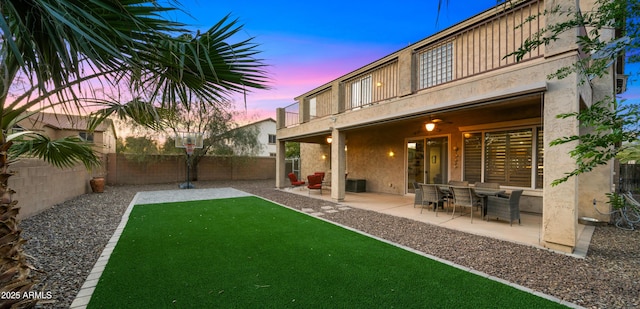 view of yard featuring a patio, a balcony, and a fenced backyard