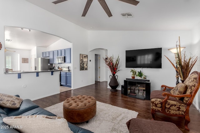 living area with visible vents, arched walkways, ceiling fan, dark wood-type flooring, and vaulted ceiling