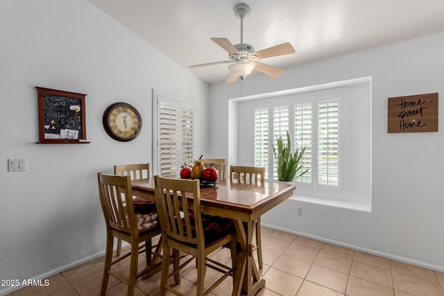 dining room featuring light tile patterned floors, baseboards, ceiling fan, and vaulted ceiling