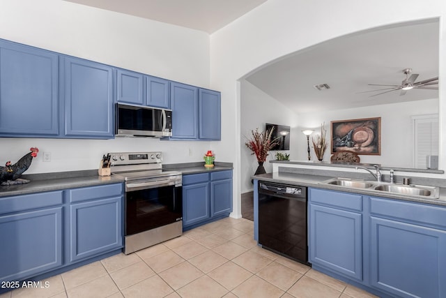 kitchen with blue cabinetry, arched walkways, stainless steel appliances, a ceiling fan, and a sink