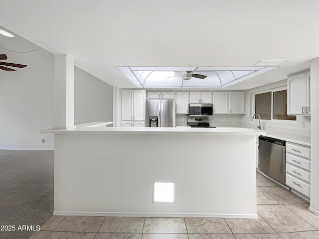 kitchen with light tile patterned floors, light countertops, stainless steel appliances, and a ceiling fan