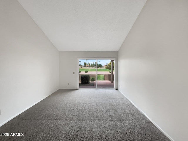 empty room featuring baseboards, lofted ceiling, and carpet