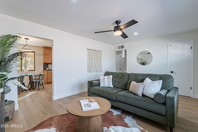 living room featuring ceiling fan and light wood-type flooring