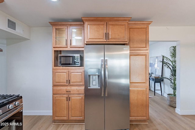 kitchen with appliances with stainless steel finishes and light hardwood / wood-style flooring