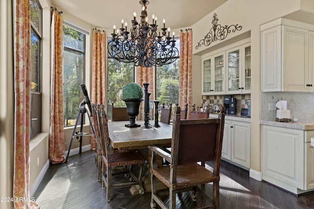 dining area featuring dark wood-type flooring and a notable chandelier