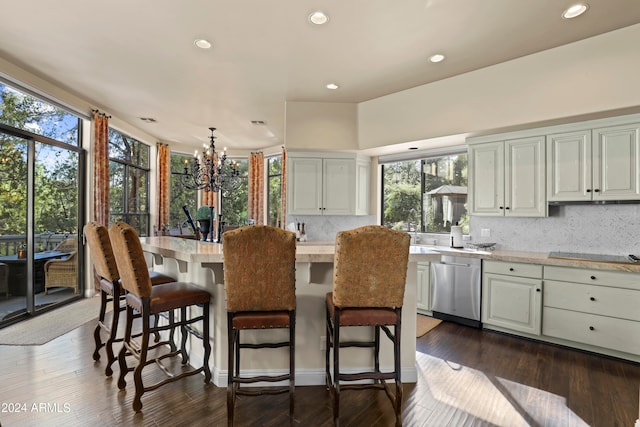 kitchen featuring dark hardwood / wood-style flooring, a wealth of natural light, dishwasher, and a center island