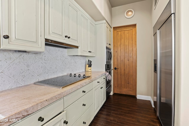 kitchen featuring backsplash, built in appliances, white cabinetry, and dark hardwood / wood-style flooring