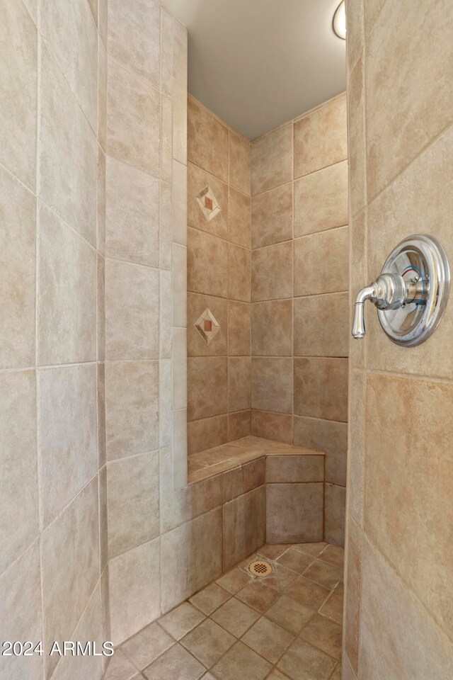 bathroom with tile patterned flooring and a tile shower