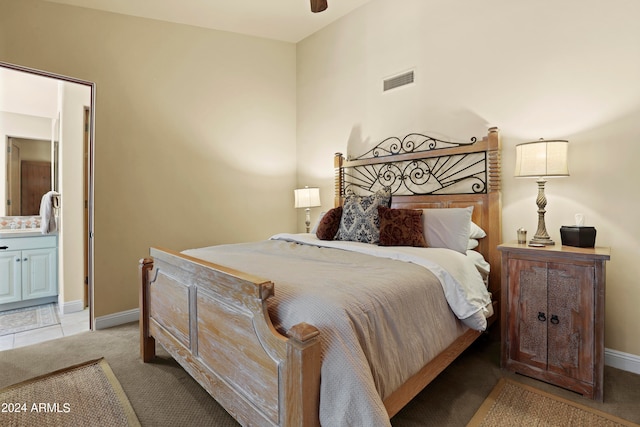 bedroom featuring ensuite bathroom, ceiling fan, and light colored carpet